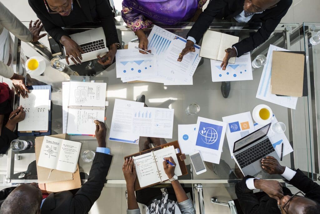 A group of people sitting around a table with papers.