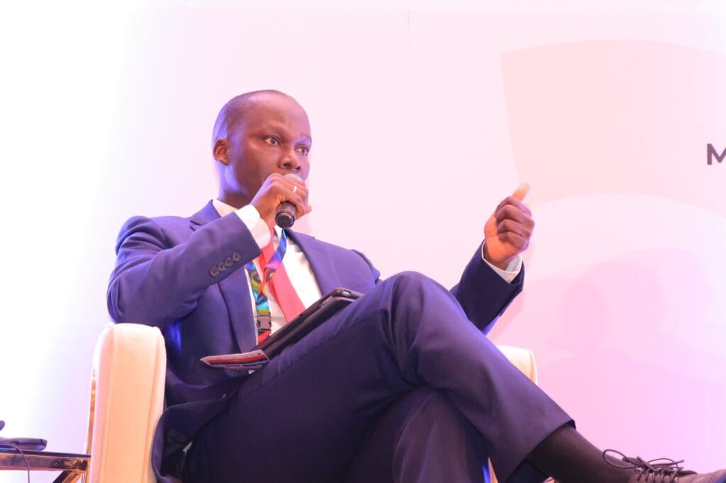 Man in suit speaking at a conference.