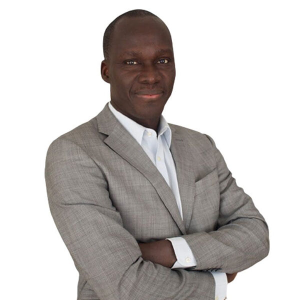 Man in grey suit with arms crossed.