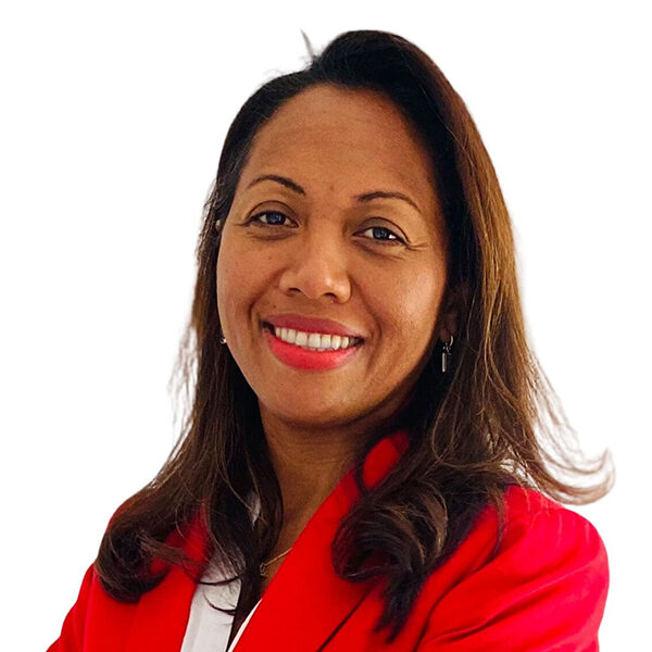 Woman in red jacket smiling against white background.