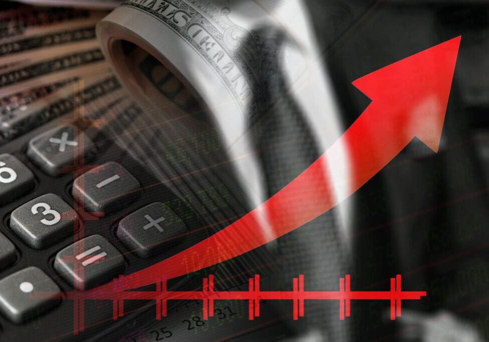 Calculator, red arrow, dollar bills, rising graph.