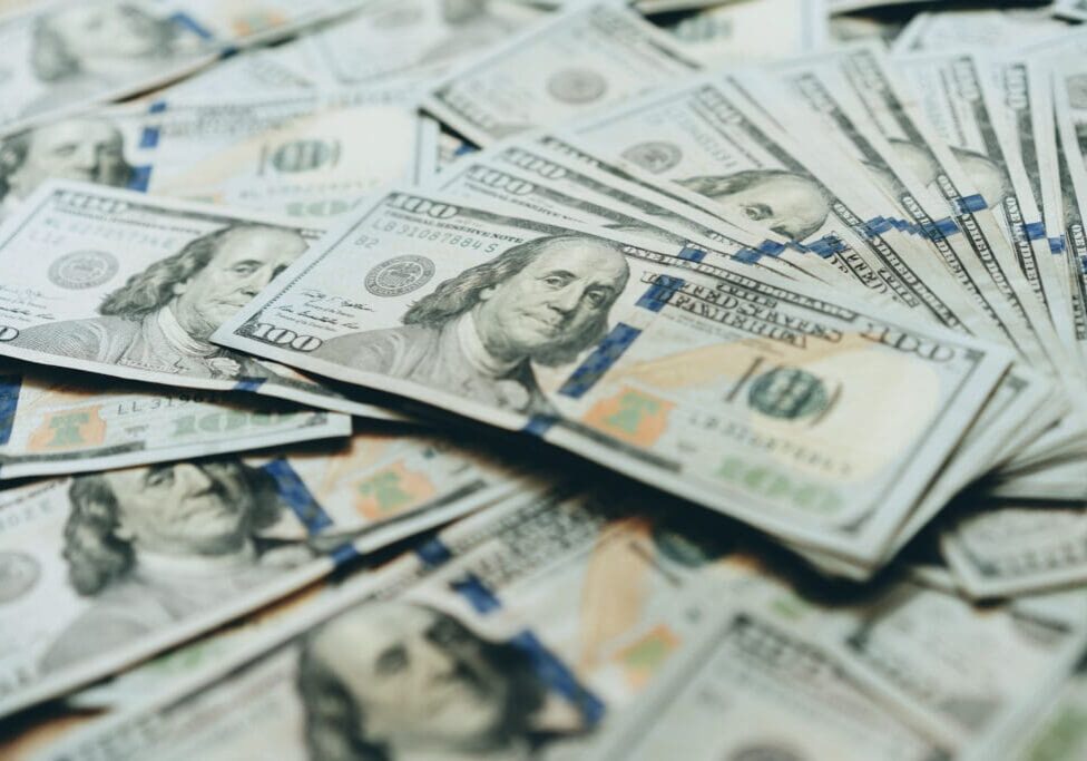 Here's an alt tag for the image: Stack of one hundred dollar bills.