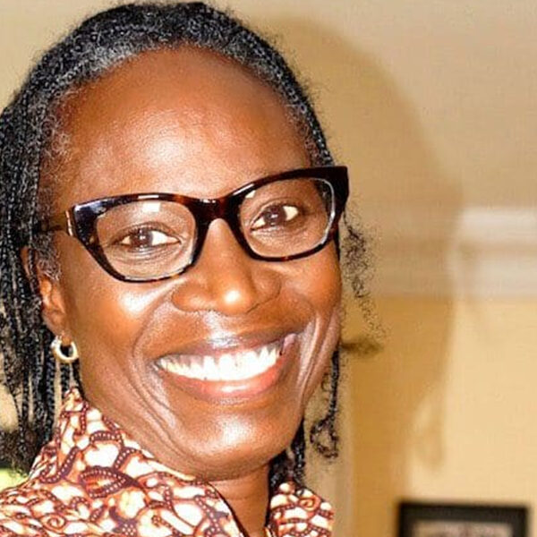 Smiling woman with glasses and braids.