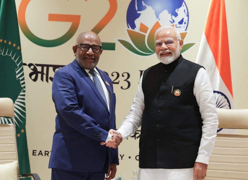 Two dignitaries shaking hands at a g20 summit event.