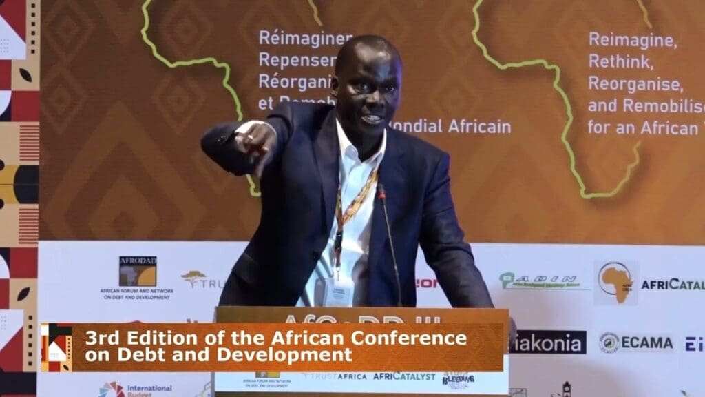 A speaker pointing towards the audience at the 3rd edition of the african conference on debt and development.