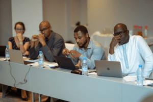 Professionals focusing on their work during a conference session.