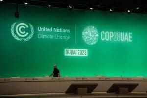 A lone individual stands before the stage of the united nations climate change conference, cop28 uae, dubai 2023.
