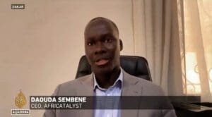 A man in a suit giving an interview on al jazeera from dakar, identified as daouda sembene, ceo of africatalyst.