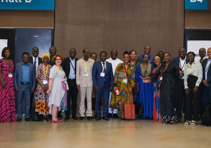 Group of individuals posing for a photo at a conference or event hall.