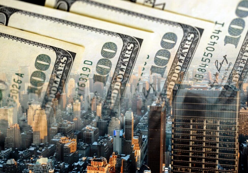 Cityscape with $100 bills overlayed.