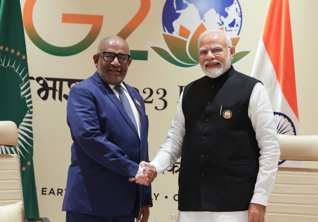 Two dignitaries shaking hands at a g20 summit event.