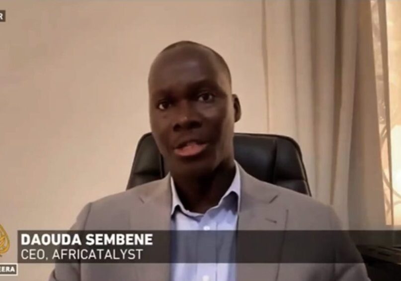 A man in a suit giving an interview on al jazeera from dakar, identified as daouda sembene, ceo of africatalyst.