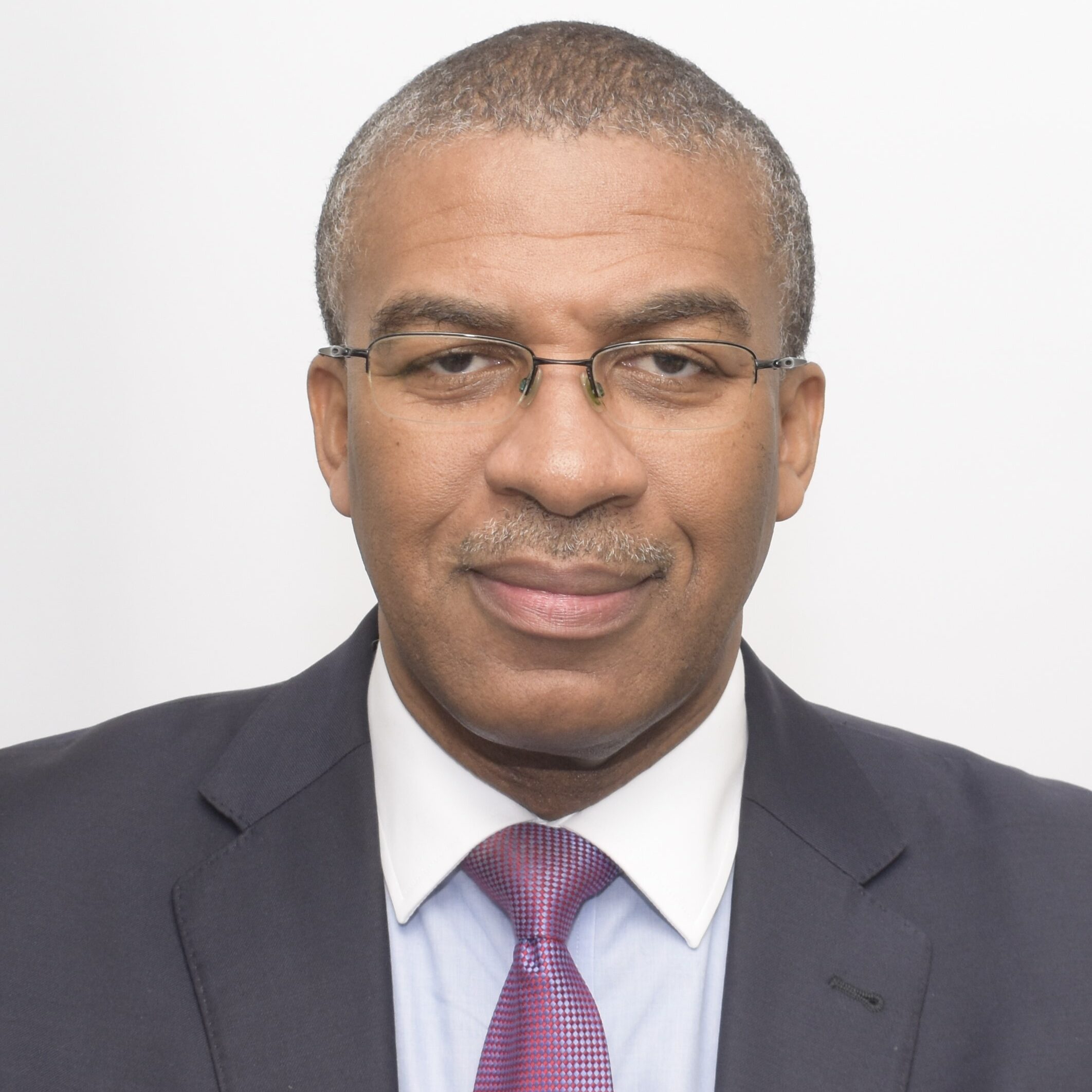 Portrait of a man in a suit and glasses.