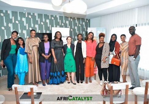 A group of individuals posing for a photo at an indoor event with the logo "africatalyst" in the background.