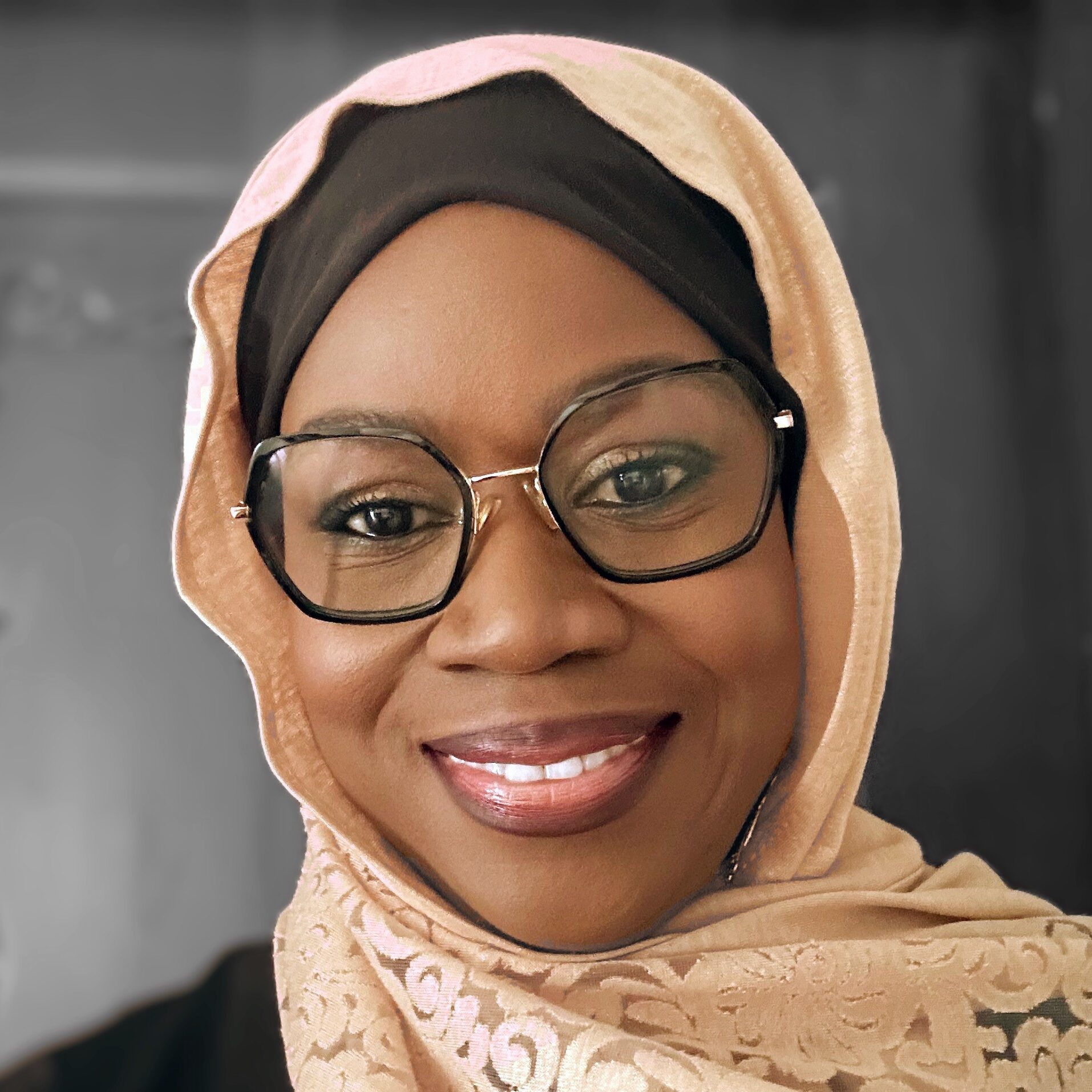 Woman wearing glasses and hijab.